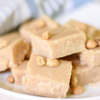 Peanut butter fudge on plate with peanuts