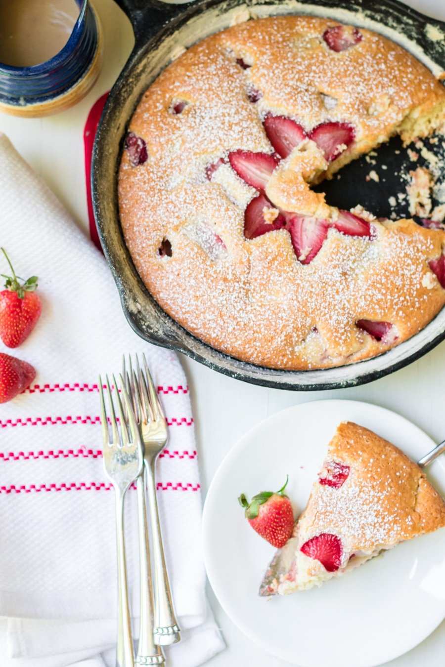 Strawberry cake in Skillet with a slice on a plate next to it