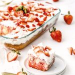 Strawberry poke cake with slice on plate