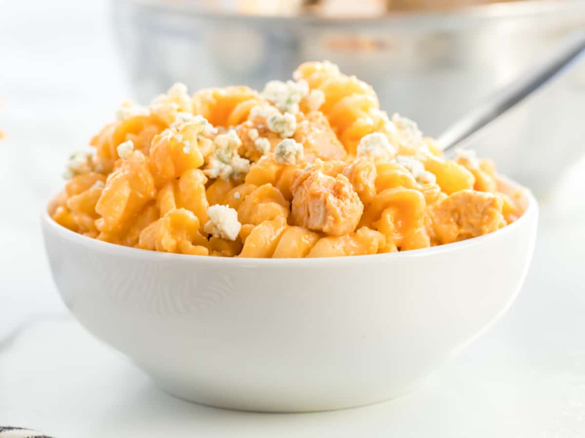 buffalo chicken mac and cheese in a white bowl with a spoon.