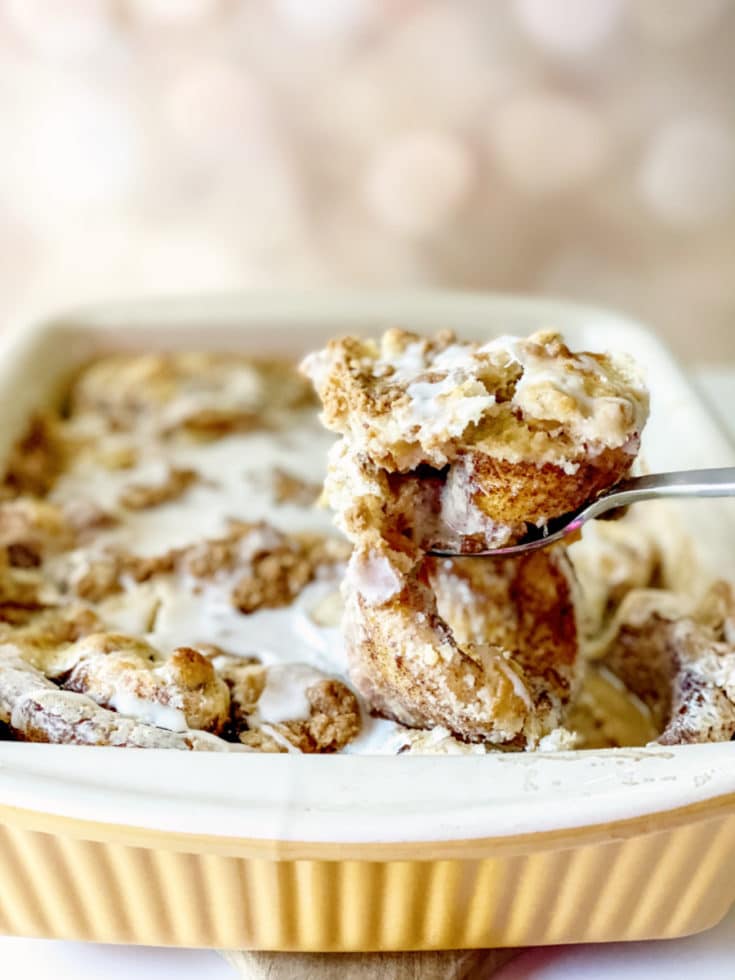 Cinnamon Roll Casserole Baked with serving on spoon