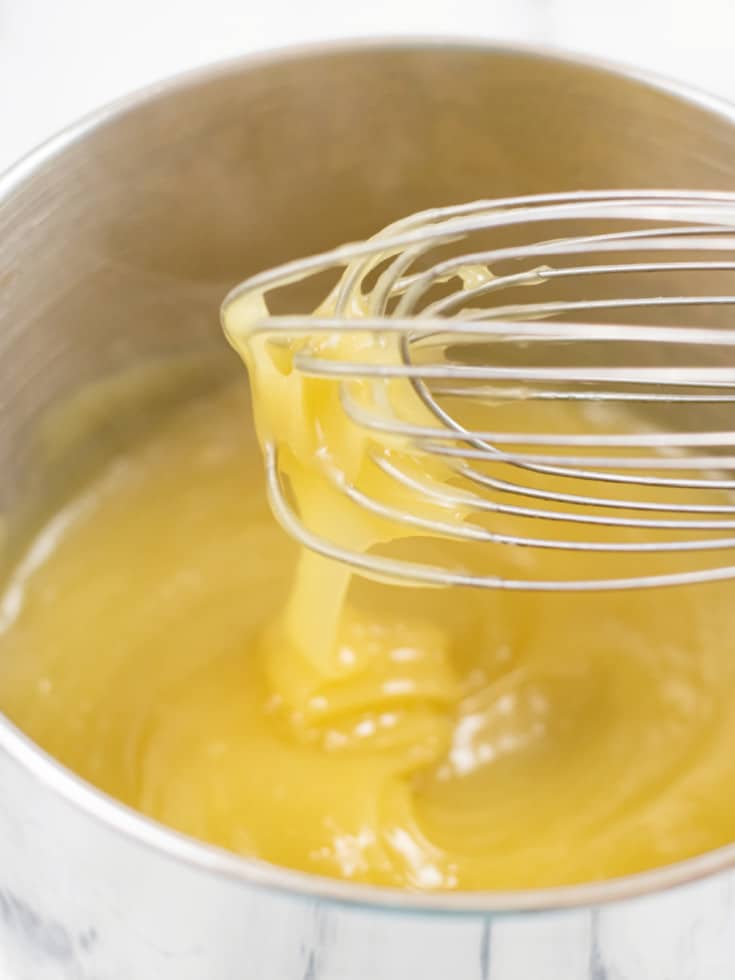pineapple topping mixture in saucepan with whisk