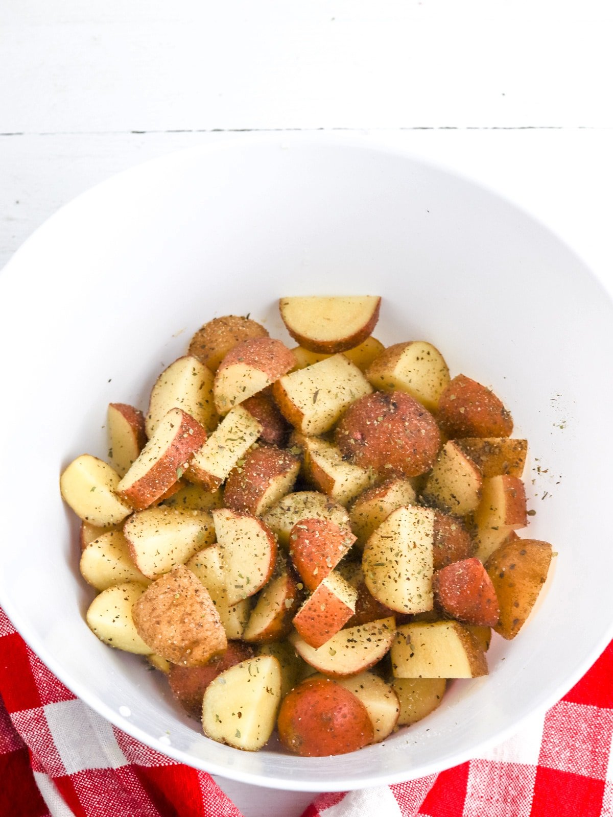 potatoes with seasoning in mixing bowl