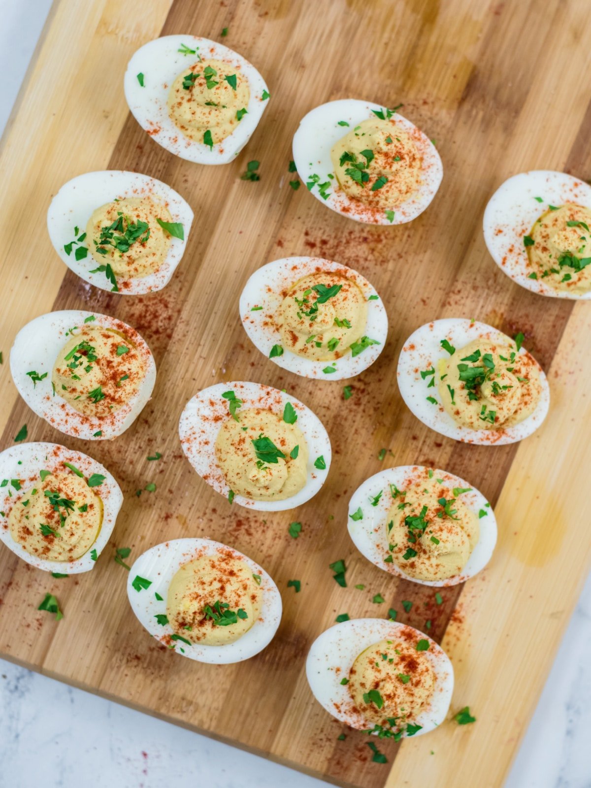 Top hummus deviled eggs with paprika and garnish