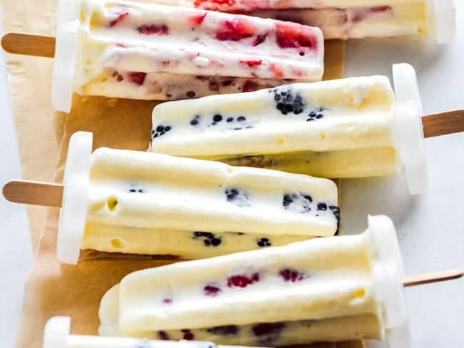 Mixed Berry Cheesecake Pudding Pops on parchment paper