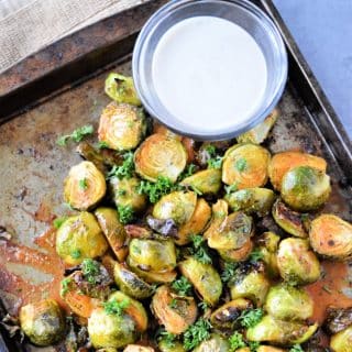 Roasted Buffalo Ranch Brussel Sprouts Recipe on a pan with bowl of ranch dressing for dipping