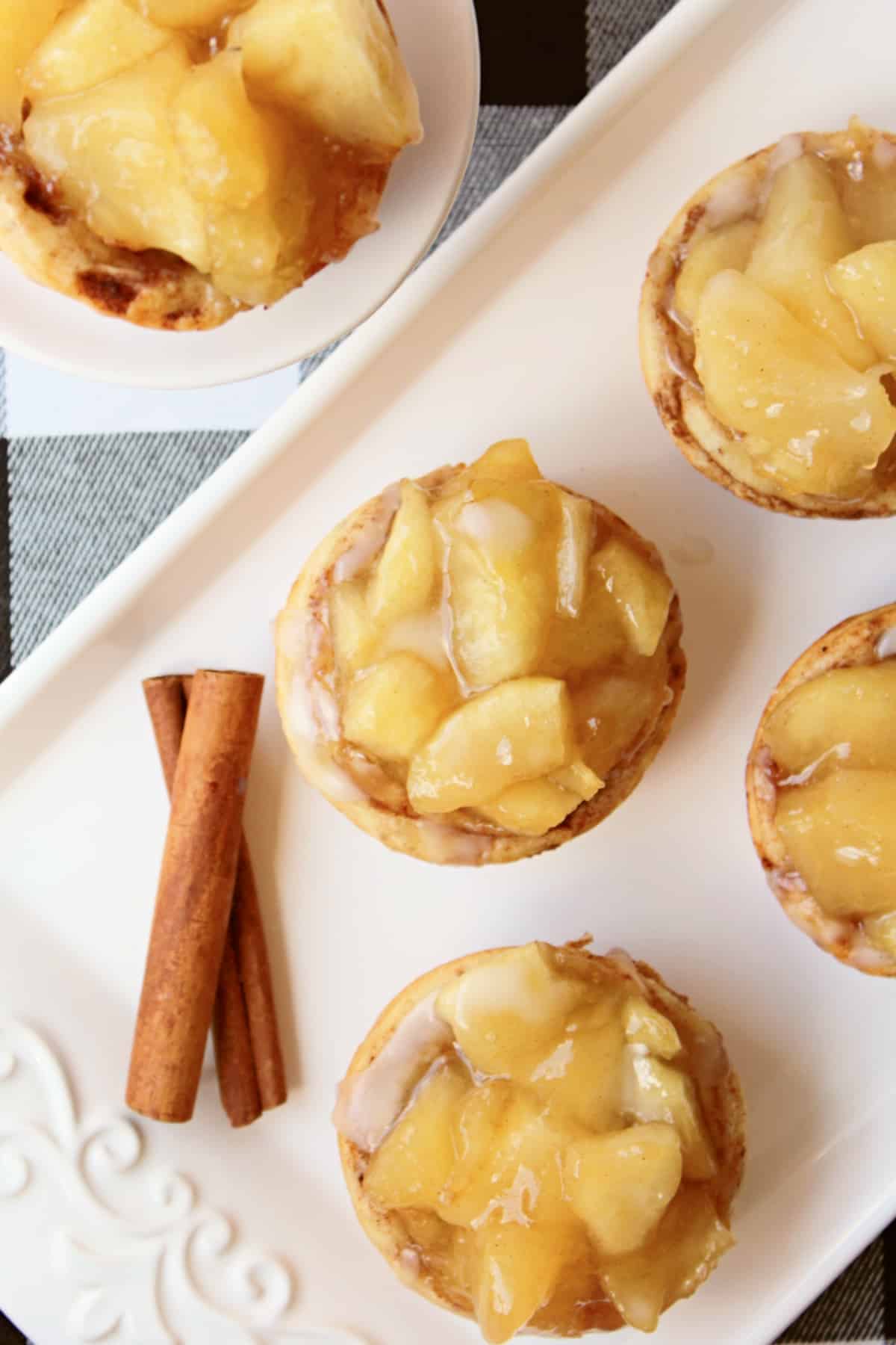 Apple Pie muffin tin mini pies on a platter with cinnamon sticks