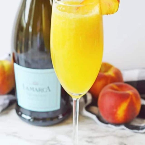 Focus photography of Peach Bellini in a champagne flute.