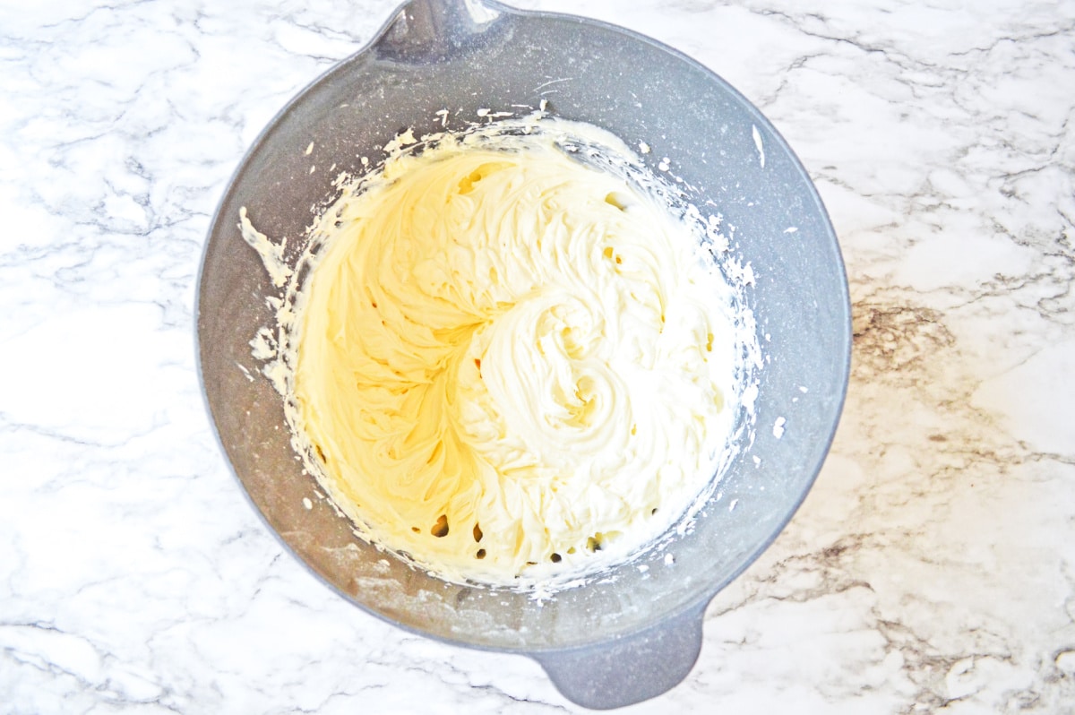 whipped cream cheese frosting in gray mixing bowl
