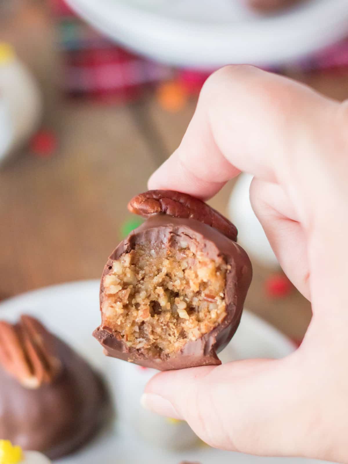 holding a pecan pie truffle with a bite missing
