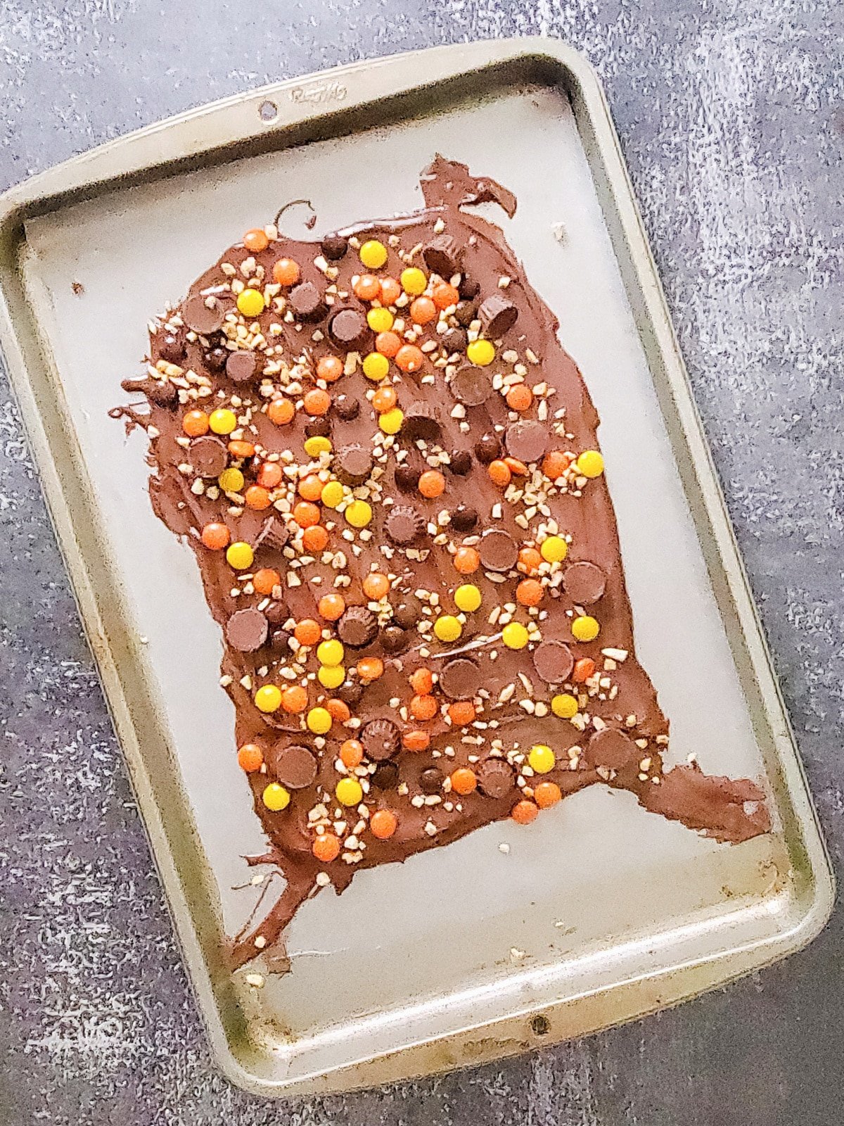 sprinkle candy and nuts onto chocolate