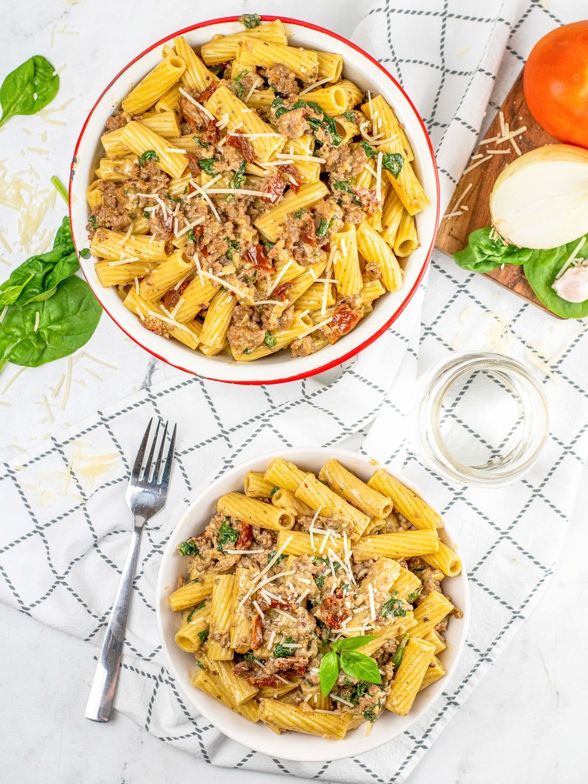 Italian sausage pasta in a serving bowl and a serving