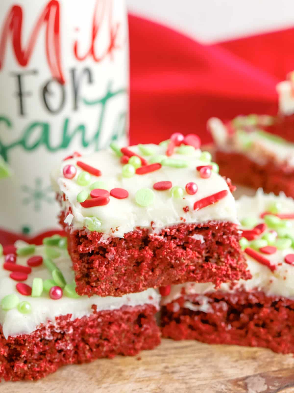 Red Velvet Cookie Bars frosted with Christmas sprinkles