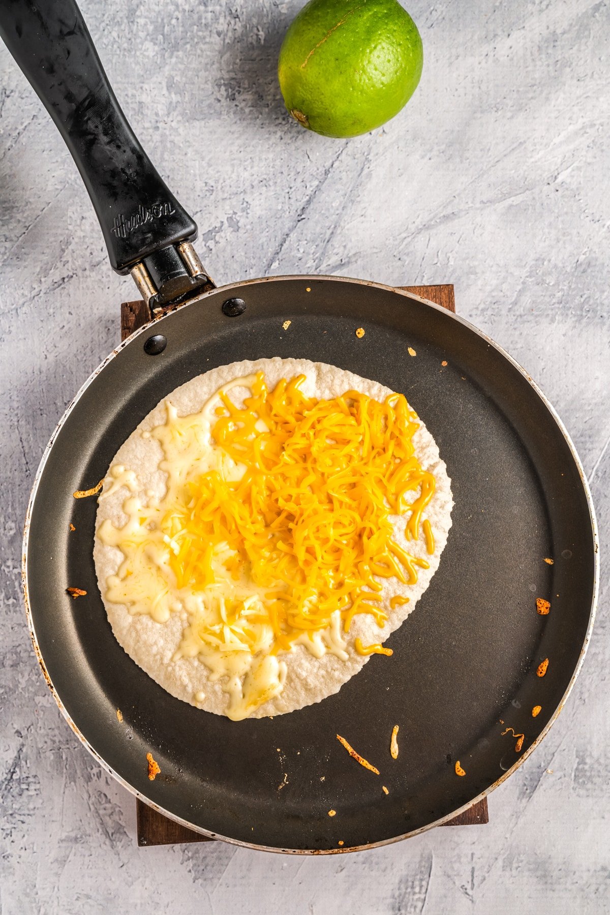 place tortilla on skillet with cheese