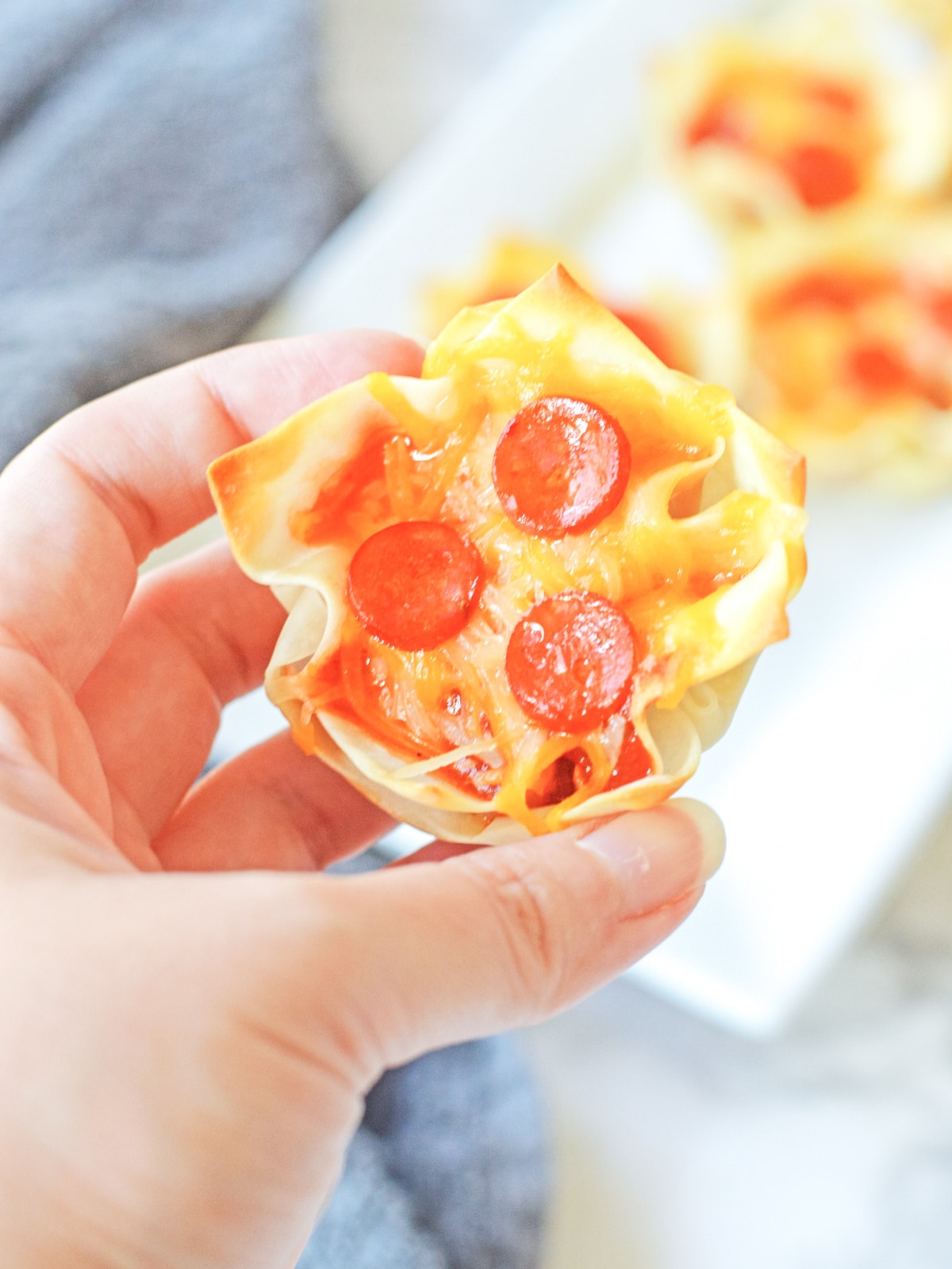 Hand holding a wonton Pizza Cup