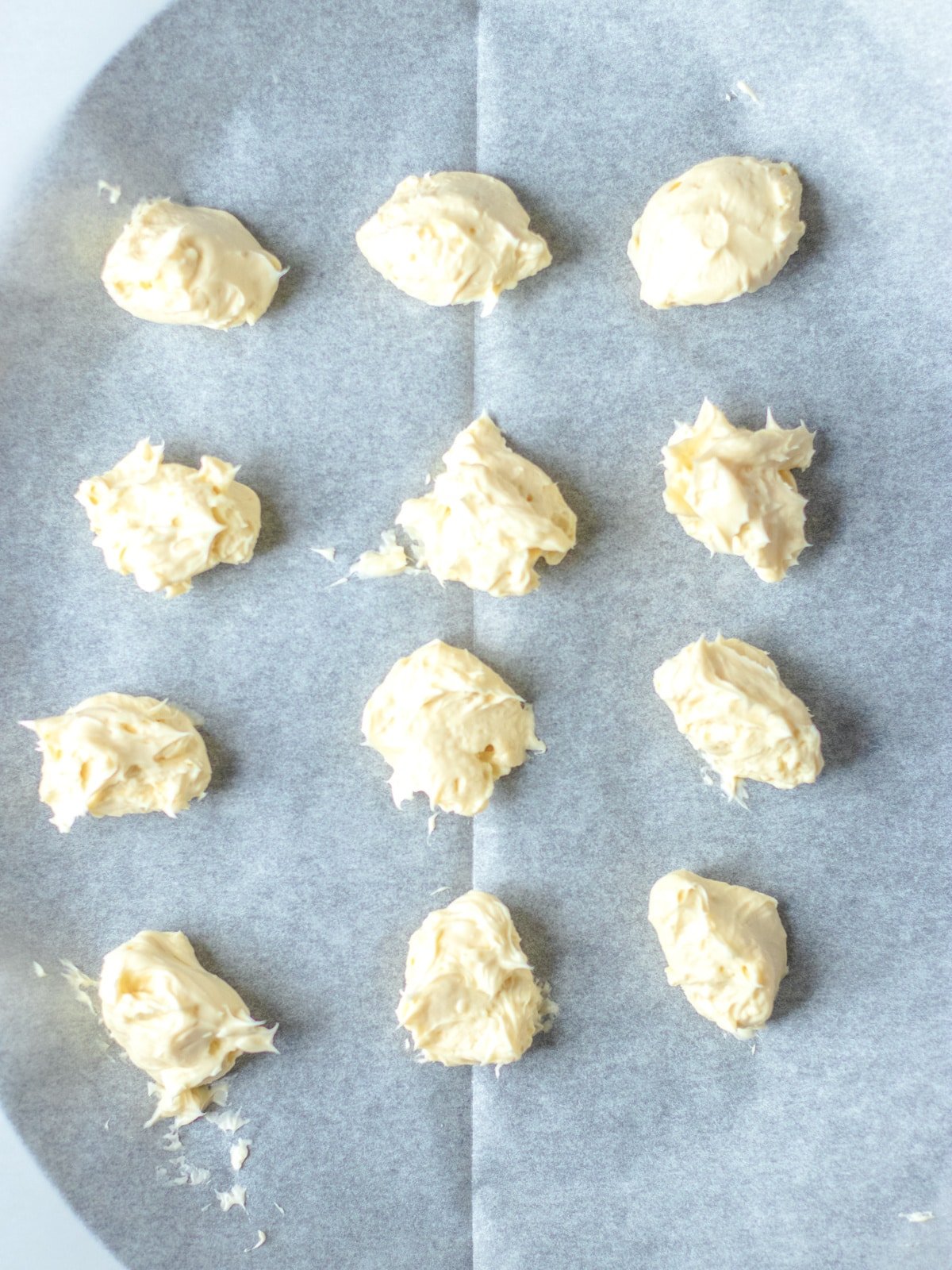 place scoops of cream cheese on parchment paper