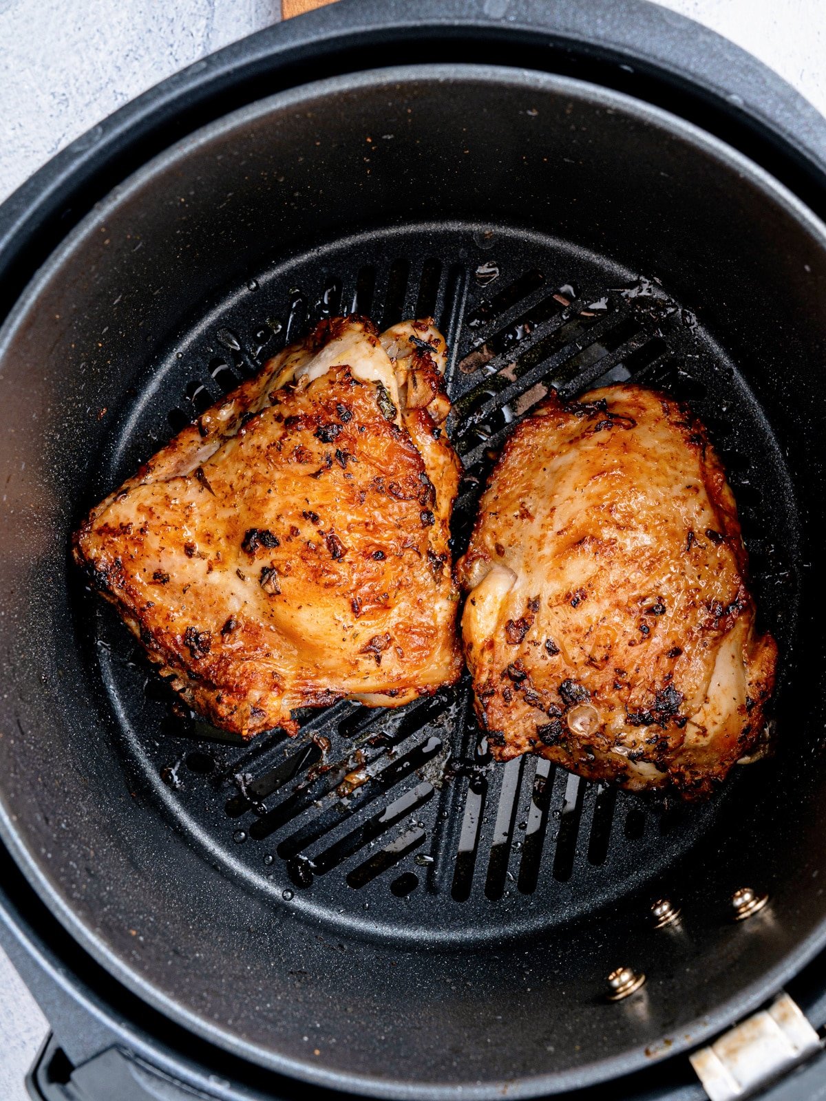 Cooked Chicken Thighs in Air Fryer Basket