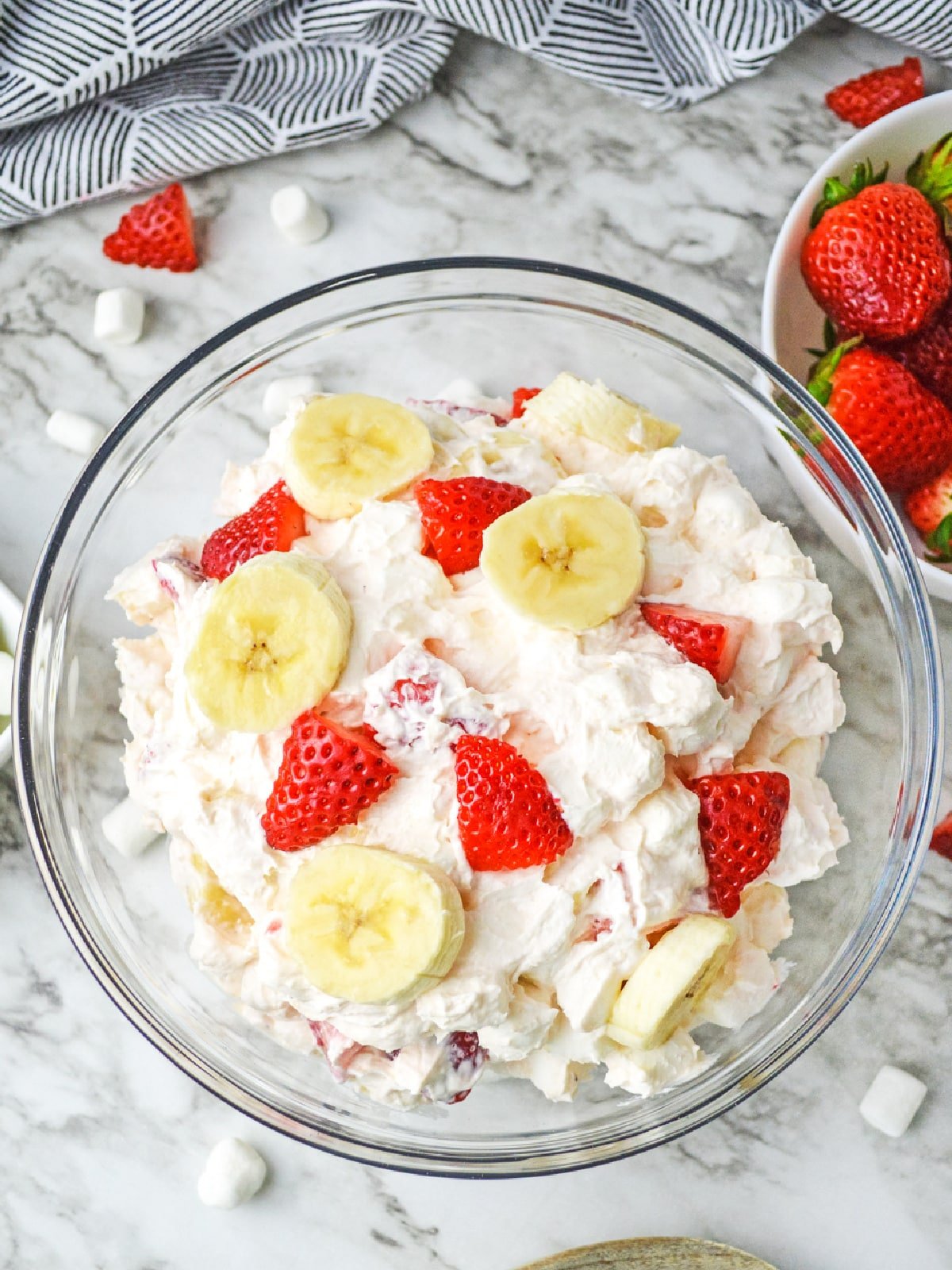 Strawberry Banana Fluff in glass bowl with sliced fruit on top