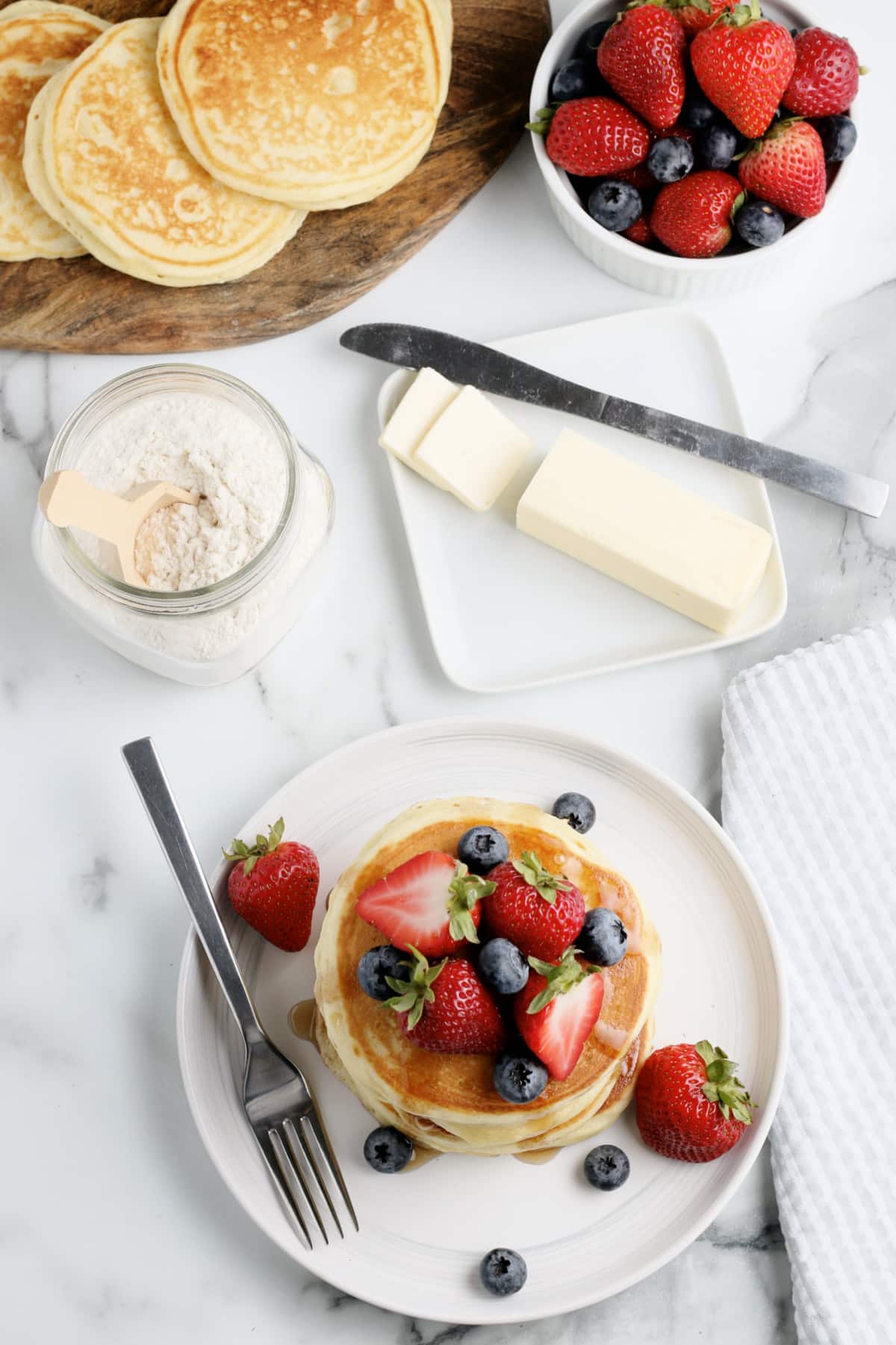 a breakfast spread with pancakes butter and fruit