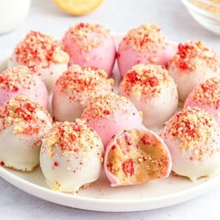 pink and white strawberry crunch cookie balls on a plate