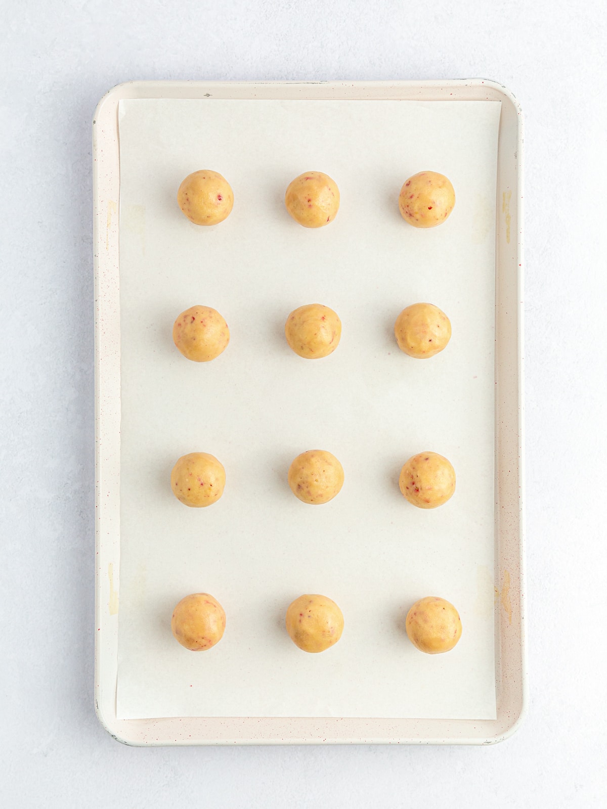 rolled cookie balls on lined cookie sheet