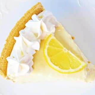 slice of no bake lemon pie with graham cracker crust on a plate