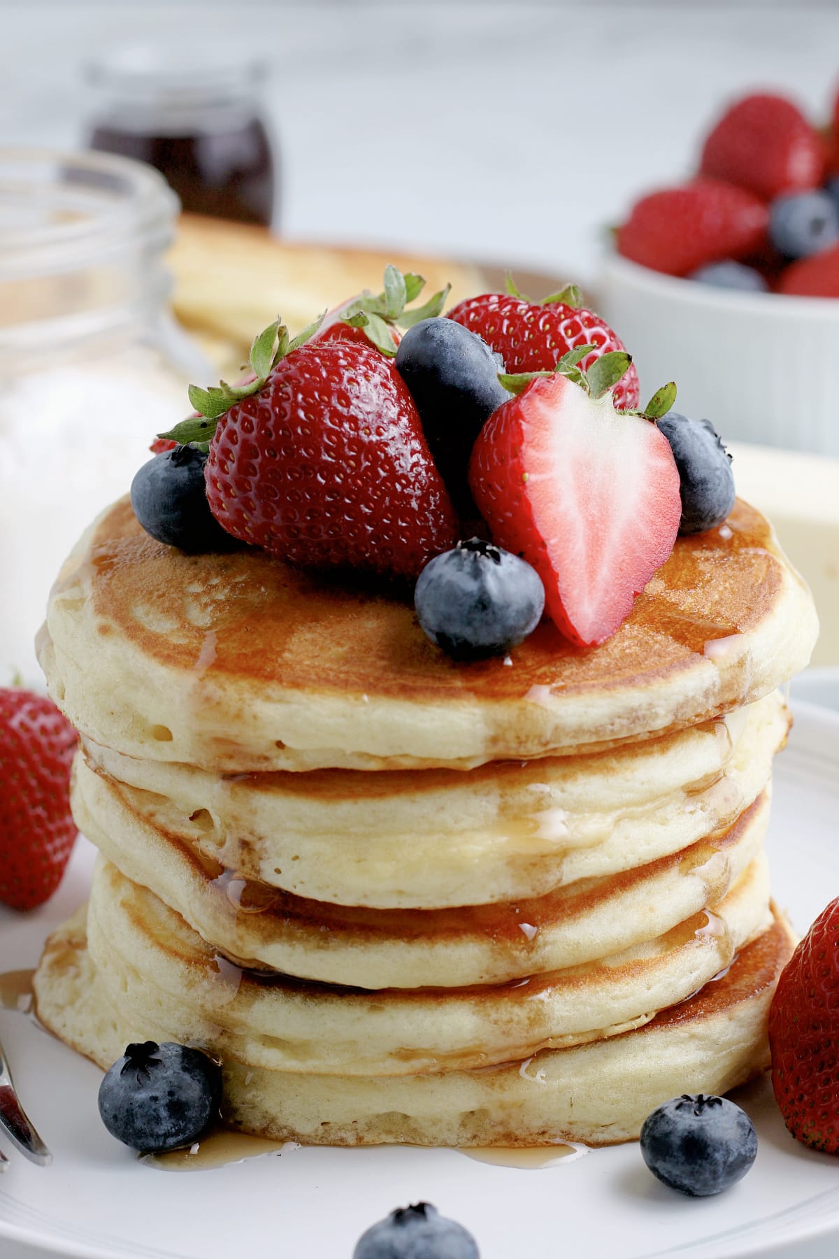 stack of pancakes with syrup and fruit