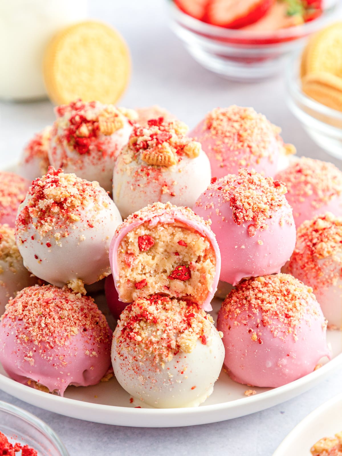 strawberry crunch cookie balls stacked on a white plate