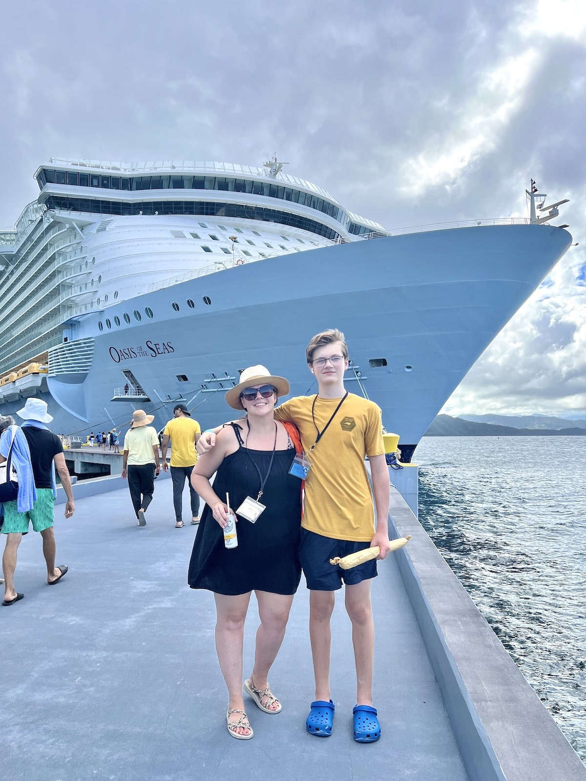 Two people standing in front of a cruise ship.