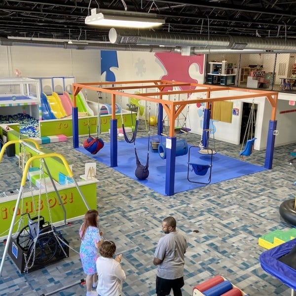 A sensory friendly children's play area with a slide and swings.
