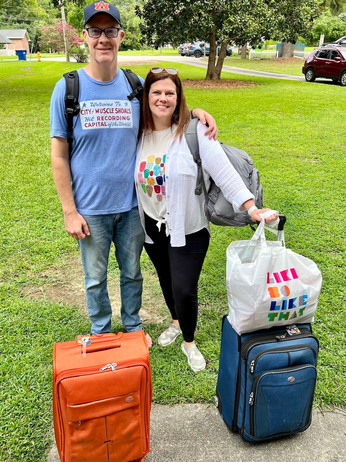 A man and woman posing with luggage.