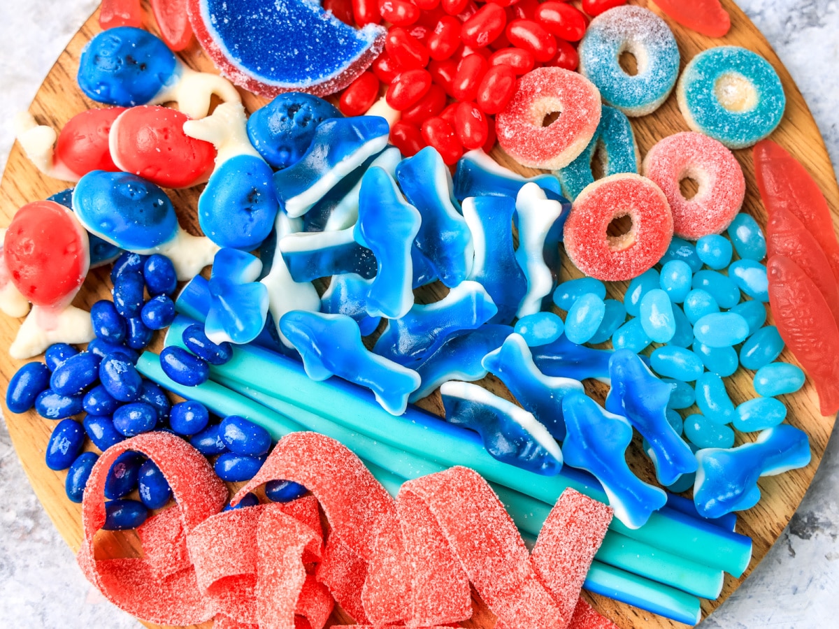 Ocean red white and blue candy gummies on a wooden cutting board.