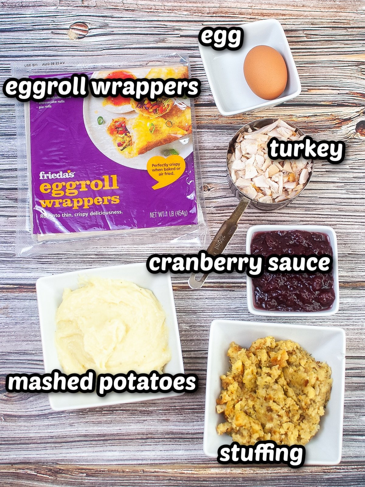 The ingredients for thanksgiving eggrolls are shown on a wooden table.