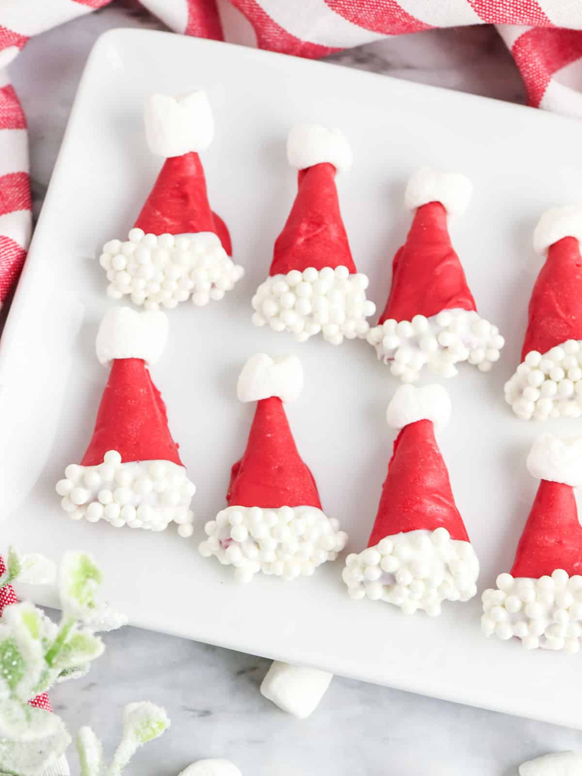 Santa hat dipped Bugles with marshmallows on a white plate.