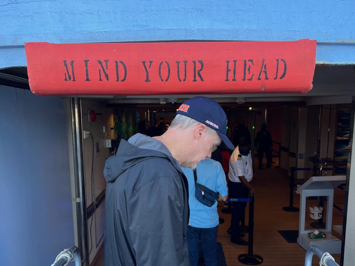 A man standing in front of a sign that says mind your head.