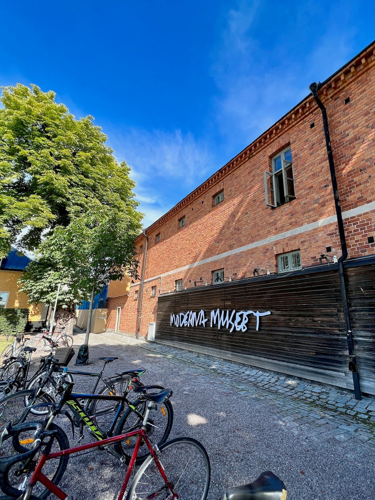 A brick building with bicycles parked in front of it.
