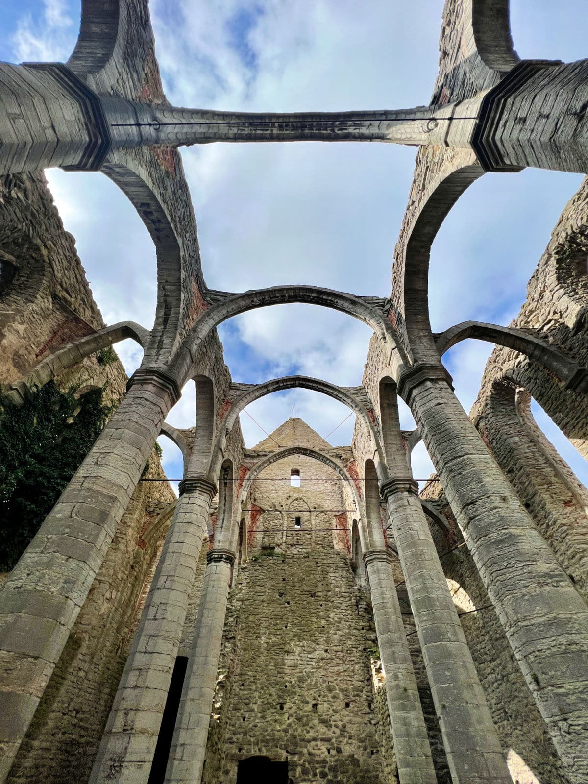 The inside of a ruined building with arches.