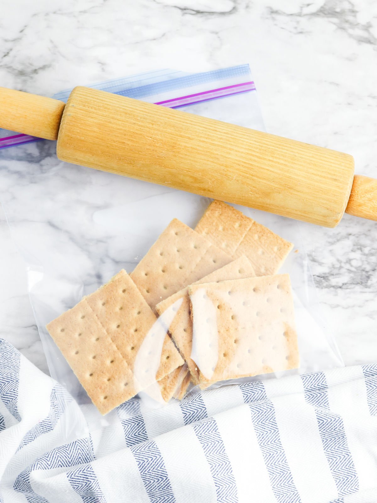 Graham crackers in a bag with a rolling pin.