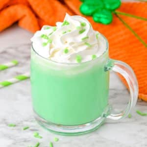 A st patrick's day drink with whipped cream and green sprinkles.