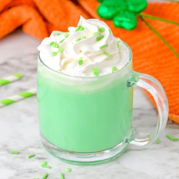 A st patrick's day drink with whipped cream and green sprinkles.