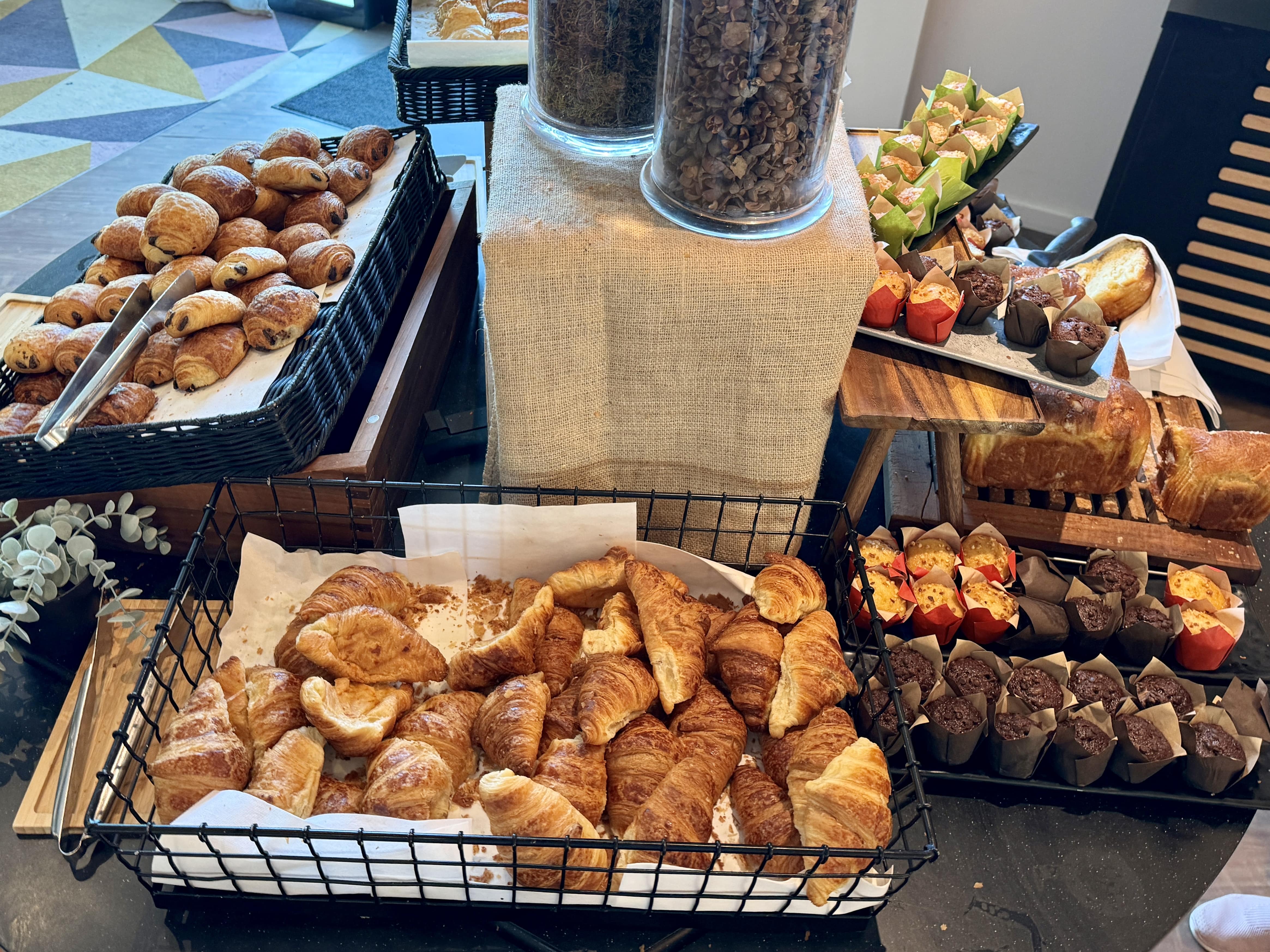 croissants and muffins on a breakfast buffet
