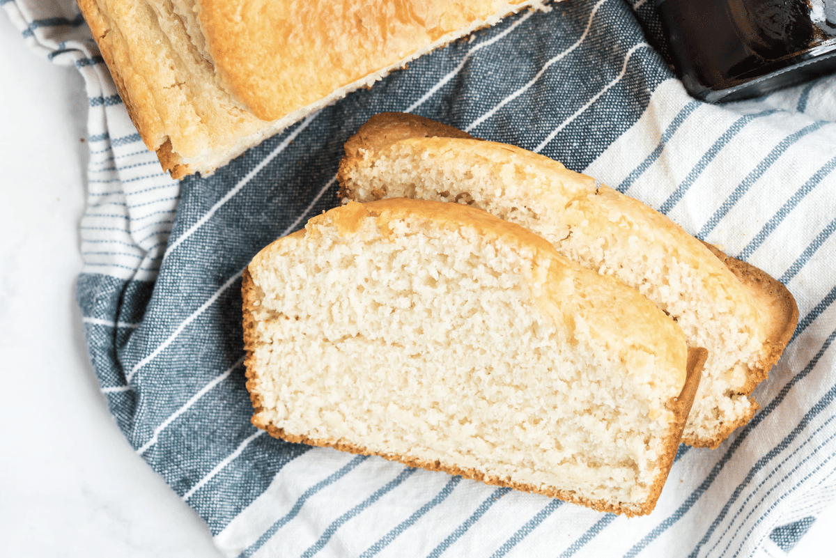 Two slices of bread on a striped towel, with a jar partially visible in the corner.