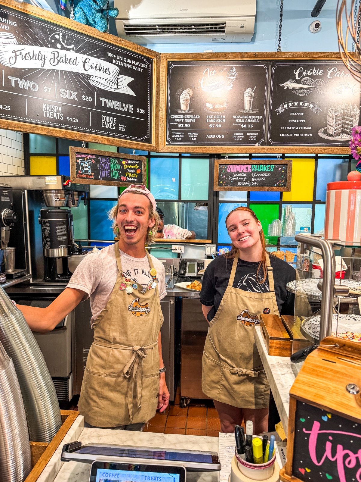 A man and woman in aprons in a restaurant.