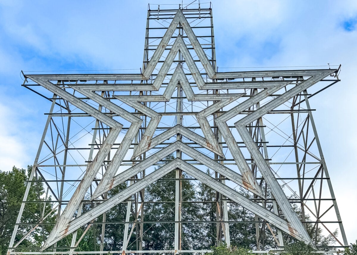 A large metal star structure stands outdoors against a backdrop of blue sky and trees, making it one of the must-see things to do in Roanoke VA.