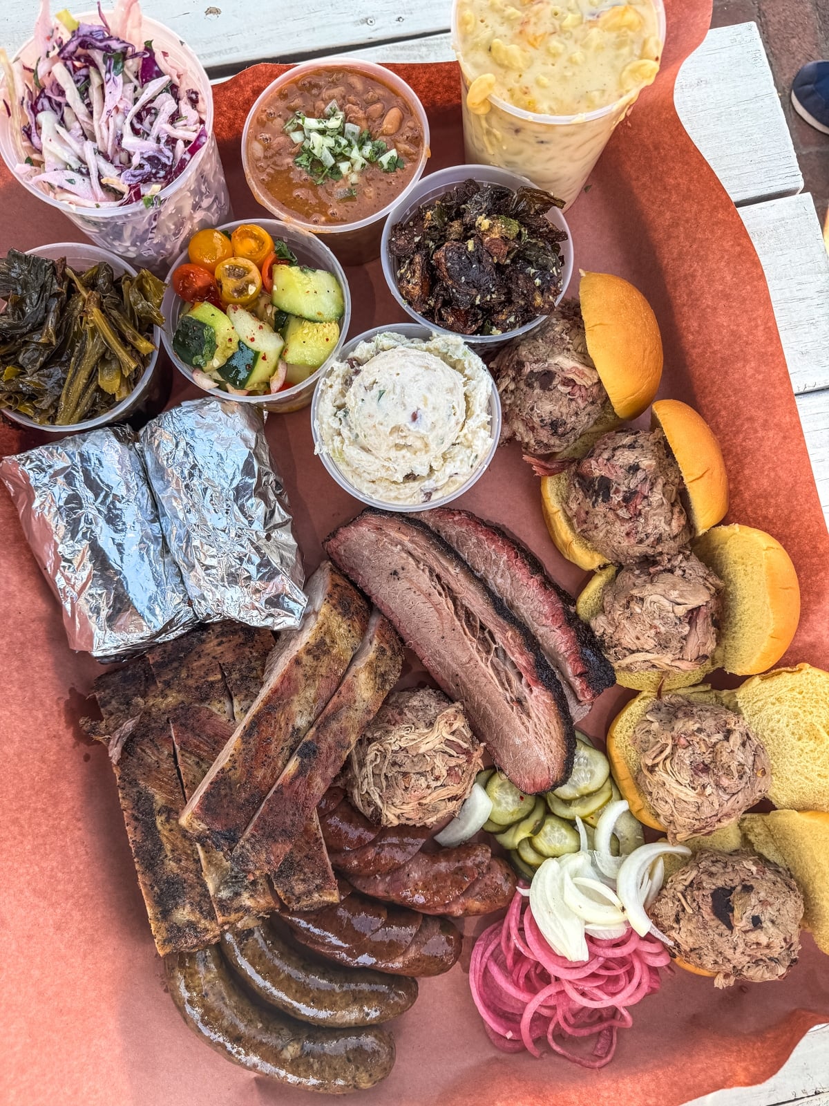 Savor a tray of assorted barbecue meats, sausages, brisket, pulled pork, buns, pickles, and classic sides&mdash;one of the tastiest things to do in Roanoke VA for food lovers.