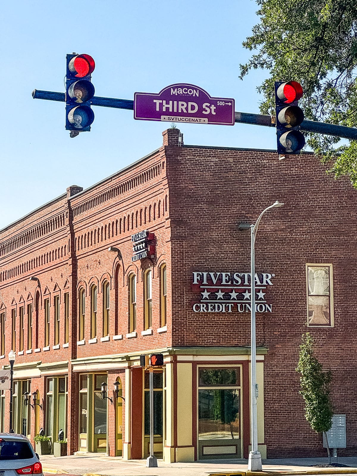 A red-brick building houses Five Star Credit Union on a street corner in Macon, under a red traffic light and a &ldquo;Third St&rdquo; sign.